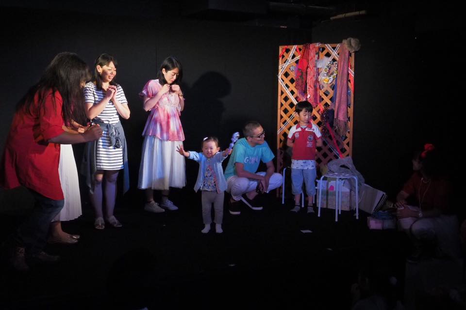 舞台で大人と子どもが一緒に即興表現を楽しむ様子